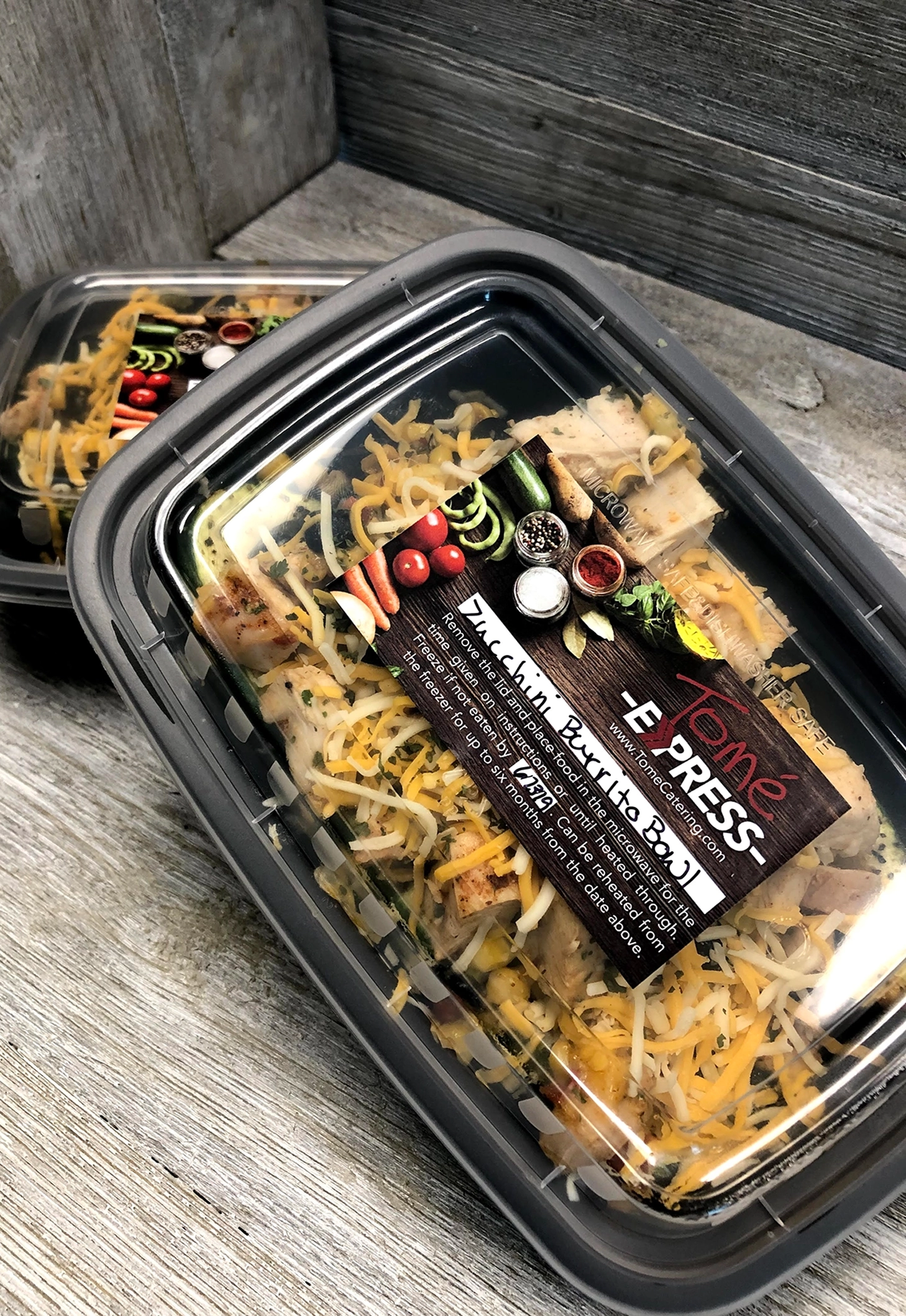 Chef-prepared chicken bowl topped with melted cheese, packaged for easy drive-thru or carry-out pickup at Tomé Express.